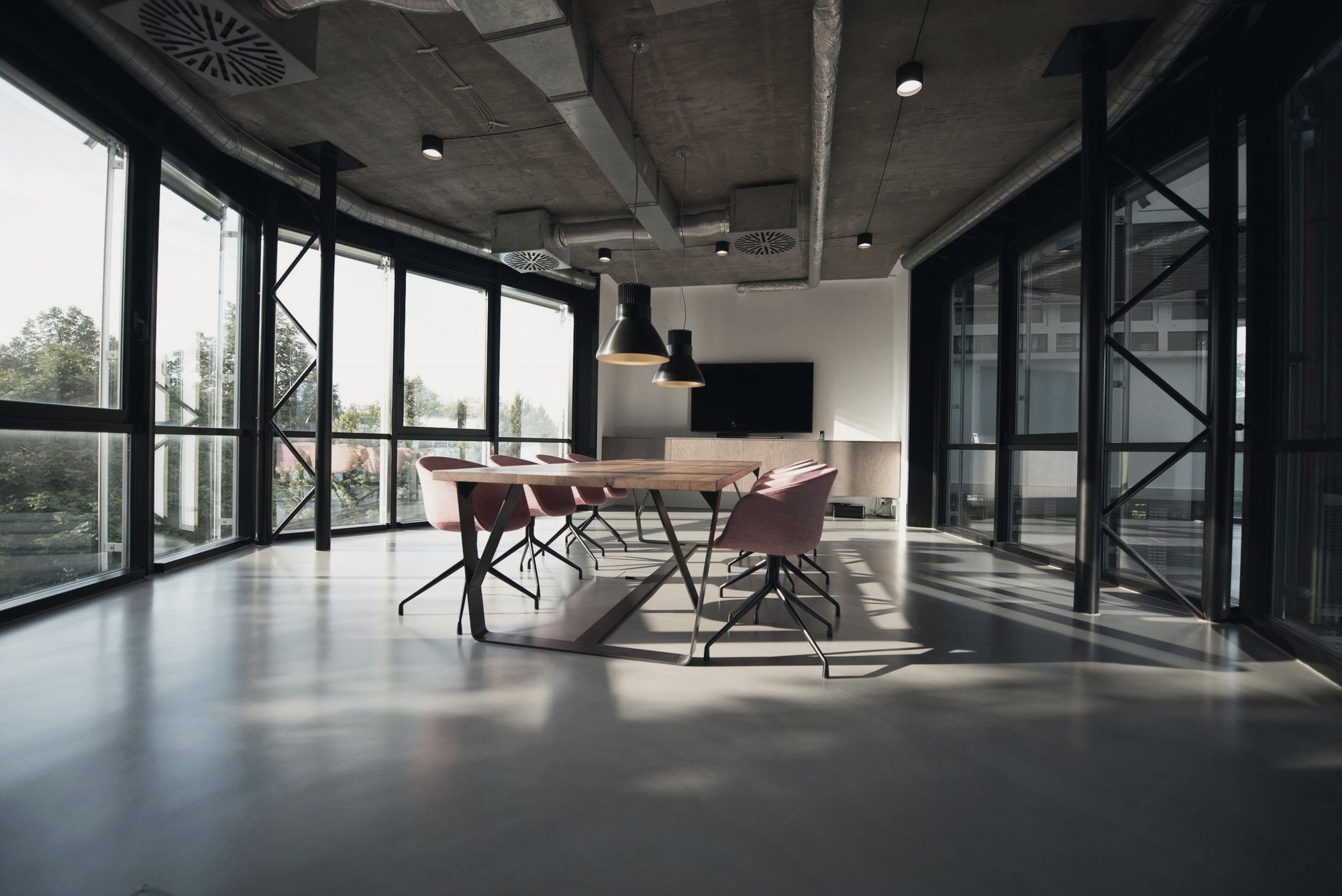 Sunlit loft boardroom with floor-to-ceiling windows